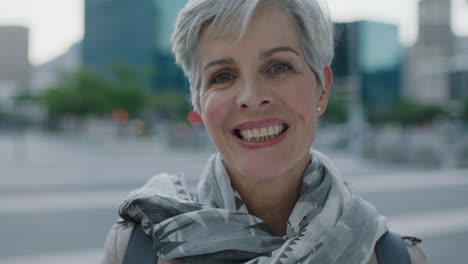 close-up-portrait-of-mature-caucasian-business-woman-looking-at-camera-smiling-cheerful-in-urban-city-background-wearing-scarf