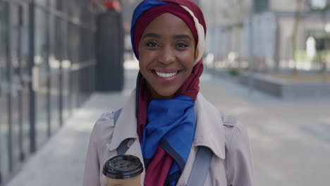 Porträt-Einer-Jungen,-Erfolgreichen-Afroamerikanischen-Geschäftsfrau,-Die-Lächelt-Und-Den-Entspannten-Urbanen-Lebensstil-Genießt.-Schöne-Schwarze-Muslimische-Frau-Mit-Traditionellem-Hijab-Kopftuch-In-Der-Stadt,-Die-Kaffee-Hält