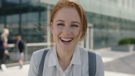 close-up-portrait-of-happy-red-head-business-woman-intern-laughing-cheerful-enjoying-corporate-career-in-city