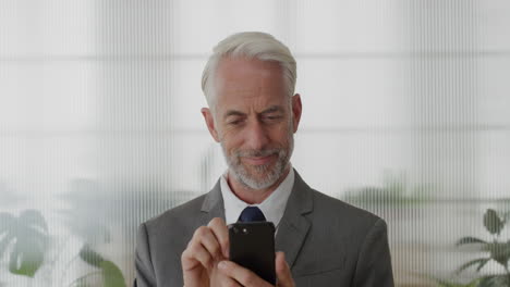 portrait-happy-mature-businessman-executive-using-smartphone-in-office-enjoying-texting-browsing-messages-sending-email-sms-on-mobile-phone-slow-motion-technology-satisfaction