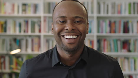 young-african-american-man-portrait-laughing-looking-at-camera-standing-in-library