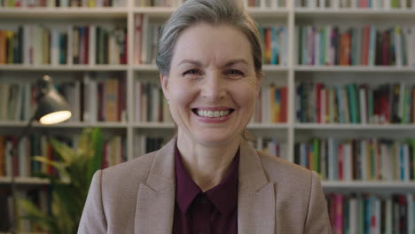 close-up-portrait-of-happy-mature-business-woman-executive-smiling-enjoying-successful-corporate-career-in-bookshelf-background