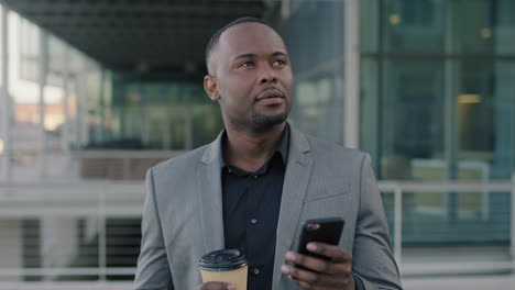 portrait-of-african-american-man-using-phone-drinking-coffee-in-city-close-up-of-businessman