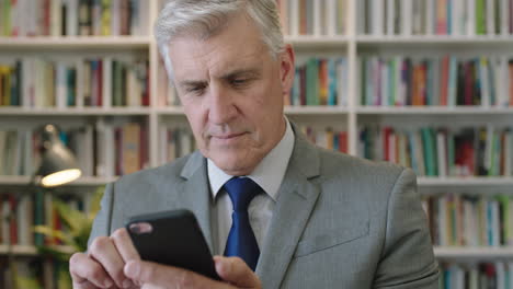 portrait-of-mature-caucasian-businessman-boss-using-smartphone-browsing-networking-laughing-cheerful-in-library-study-office
