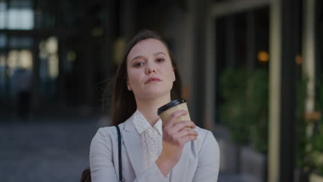 portrait-young-attractive-business-woman-looking-serious-corporate-professional-holding-coffee-wind-blowing-hair-in-urban-outdoors-background-ambition-success