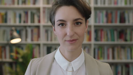 close-up-portrait-of-young-beautiful-woman-librarian-looking-at-camera-pensive-thinking-wearing-stylish-suit-in-library-bookshelf-background