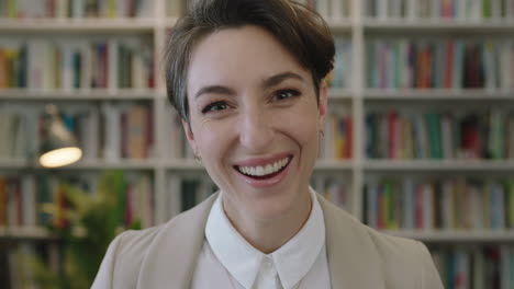 portrait-of-young-beautiful-caucasian-woman-laughing-cheerful-enjoying-career-opportunity-successful-female-looking-at-camera-in-library-bookshelf-background