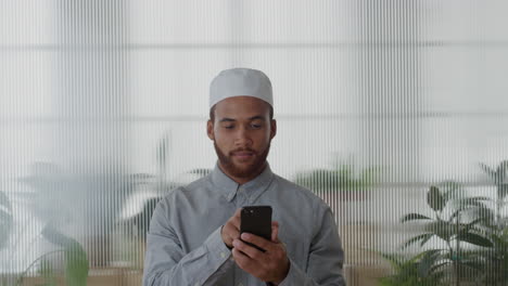 Retrato-Joven-Hombre-De-Negocios-Musulmán-Usando-Un-Teléfono-Inteligente-En-La-Oficina-Disfrutando-De-Mensajes-De-Texto-Navegando-En-Un-Teléfono-Móvil-Enviando-Sms-Correo-Electrónico-Sonriendo-Feliz-Satisfacción-Cámara-Lenta