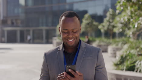 portrait-young-successful-african-american-businessman-using-smartphone-in-city-enjoying-relaxed-sunny-day-texting-browsing-messages-on-mobile-phone-smiling-happy-entrepreneur-communicating-online