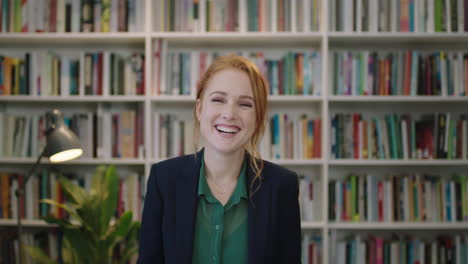 portrait-of-beautiful-young-red-head-business-woman-intern-laughing-happy-enjoying-professional-career-opportunity-in-library-background