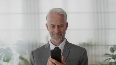 portrait-happy-senior-businessman-executive-using-smartphone-in-office-enjoying-texting-browsing-messages-sending-email-sms-on-mobile-phone-slow-motion-technology-satisfaction