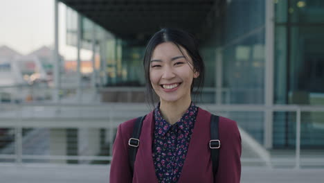 Porträt-Einer-Jungen-Asiatischen-Studentin,-Die-Glücklich-Lacht-Und-Auf-Dem-Campus-Der-Universität-Steht