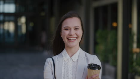 portrait-young-confident-business-woman-laughing-enjoying-relaxed-lifestyle-holding-coffee-wind-blowing-hair-in-urban-outdoors-background-ambition-success
