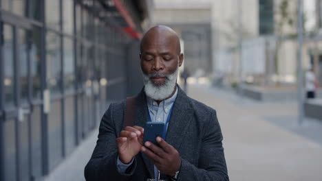 Retrato-Exitoso-Hombre-De-Negocios-Afroamericano-Senior-Usando-Un-Teléfono-Inteligente-En-La-Ciudad-Disfrutando-Navegando-Mensajes-En-Línea-Enviando-Mensajes-De-Texto-En-Cámara-Lenta-De-Teléfono-Móvil