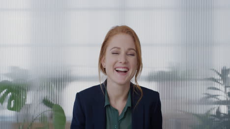 portrait-young-happy-red-head-business-woman-laughing-enjoying-successful-corporate-lifestyle-running-hand-through-hair-slow-motion