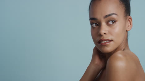 Porträt-Einer-Schönen-Afroamerikanerin,-Die-Ihren-Körper-Mit-Der-Hand-Berührt,-Einen-Glatten,-Gesunden-Teint-Streichelt-Und-Die-Perfekte-Natürliche-Schönheit-Genießt,-Die-Selbstbewusst-Auf-Blauem-Hintergrund-Aussieht.-Hautpflegekonzept