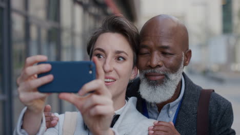 Porträt-Eines-Glücklichen-Multiethnischen-Paares,-Das-Mit-Dem-Smartphone-Selfie-Fotos-Macht-Und-Dabei-Genießt,-Gemeinsam-Spaß-In-Der-Zeitlupenserie-Echter-Menschen-In-Der-Stadt-Zu-Haben