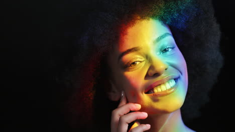Mehrfarbiges-Porträt,-Schöne-Frau-Mit-Flippigem-Afro-Lächeln,-Selbstbewusst,-Genießend-Den-Individuellen-Ausdruck,-Natürliche,-Feminine-Schönheit,-Buntes-Licht-Auf-Schwarzem-Hintergrund,-LGBT-Stolz-Konzept