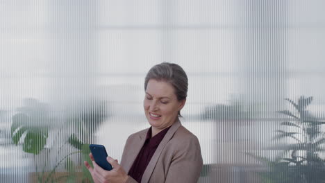 portrait-successful-mature-business-woman-boss-using-smartphone-enjoying-browsing-online-messages-texting-on-mobile-phone-smiling-satisfaction-slow-motion