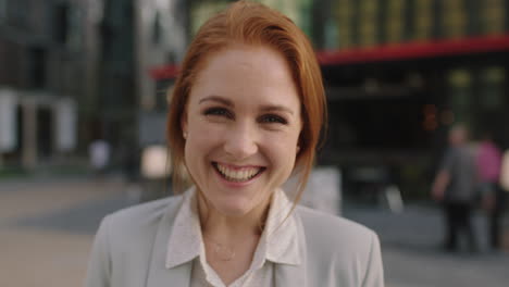 close-up-portrait-of-happy-red-head-business-woman-laughing-cheerful-enjoying-corporate-career-in-city-sunset-commuting