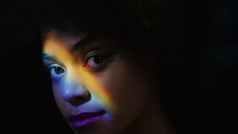 Nahaufnahme-Eines-Regenbogenporträts,-Schöne-Afroamerikanische-Frau-Mit-Afro,-Die-Einen-Glatten,-Gesunden-Teint-Genießt-Und-Selbstbewusst-Aussieht,-Natürliche-Schönheit,-Buntes-Licht-Auf-Schwarzem-Hintergrund,-Hautpflegekonzept