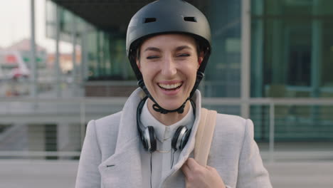 portrait-of-cheerful-young-business-woman--intern-wearing-bicycle-safety-helmet-laughing-happy-enjoying-new-corporate-career-in-city