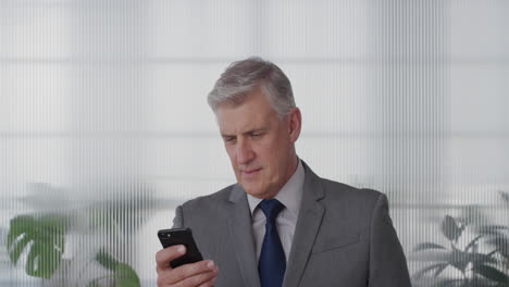 portrait-successful-mature-businessman-executive-using-smartphone-enjoying-texting-browsing-messages-sending-email-sms-on-mobile-phone-in-office-slow-motion
