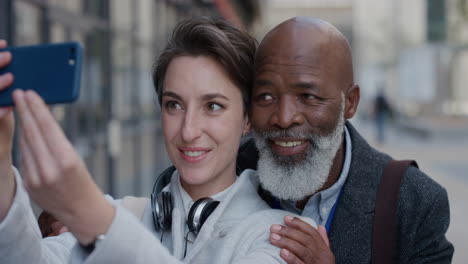 portrait-happy-multiracial-couple-using-smartphone-taking-selfie-photos-posing-enjoying-having-fun-together-in-city-slow-motion-real-people-series