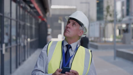 portrait-senior-construction-engineer-man-using-smartphone-taking-photos-working-on-site-planning-engineering-project-wearing-safety-helmet-slow-motion-professional-career