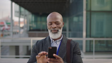 Porträt-Eines-Afroamerikanischen-Geschäftsmannes-Mittleren-Alters,-Der-SMS-Schreibt-Und-Mit-Smartphone-Mobiltechnologie-Surft,-Der-Lächelt-Und-Das-Lesen-Von-Nachrichten-Genießt