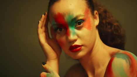 Nahaufnahme-Eines-Farbenfrohen-Porträts-Einer-Schönen-Frau-Mit-Fluoreszierender-Gesichtsbemalung,-Exotischer-Mehrfarbiger-Körperkunst-Mit-Blinkendem-UV-Licht,-Extremem-Make-up-Konzept