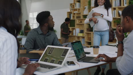 Jóvenes-Empresarios-Afroamericanos-Se-Reúnen-Con-Desarrolladores-De-Software,-Diseñan-Equipos-De-Aplicaciones-Móviles,-Colegas,-Intercambian-Ideas-Creativas-Usando-Una-Tableta,-Colaborando-En-Una-Oficina-De-Inicio.