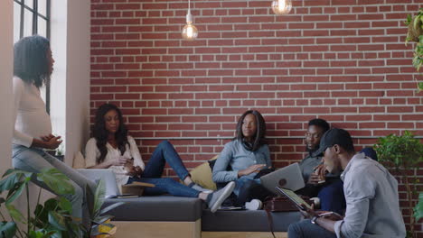 Jóvenes-Empresarios-Negros-Se-Reúnen-Para-Intercambiar-Ideas-Trabajando-Colaborando-En-Un-Proyecto-Corporativo-Gerente-Embarazada-Mujer-Compartiendo-Ideas-Entrenando-A-Colegas-En-Un-Lugar-De-Trabajo-De-Oficina-Moderno-Y-Relajado