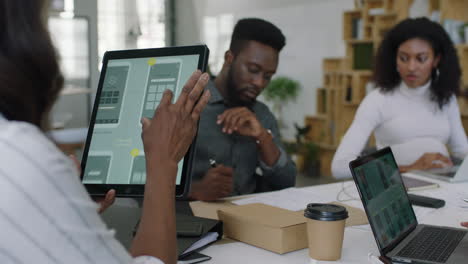 Junge-Afroamerikanische-Geschäftsleute-Treffen-Sich-Beim-Softwareentwicklerteam-Beim-Design-Mobiler-Anwendungen,-Beim-Brainstorming-Beim-Austausch-Kreativer-Ideen-Mithilfe-Eines-Tablet-Computers-Und-Bei-Der-Zusammenarbeit-Im-Startup-Büro