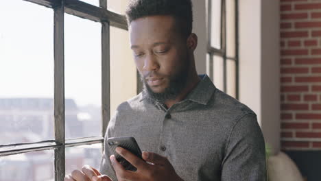 portrait-young-african-american-man-using-smartphone-drinking-coffee-at-home-browsing-messages-networking-texting-social-media-sharing-lifestyle-online-enjoying-relaxing-in-modern-apartment-close-up
