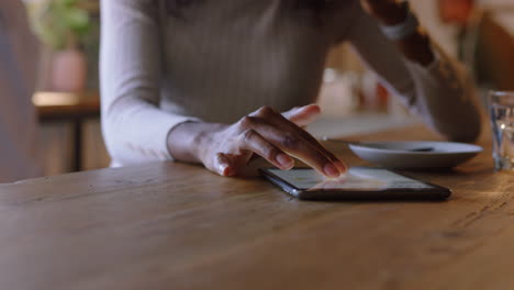 african-american-business-woman-using-tablet-computer-in-cafe-drinking-coffee-browsing-reading-online-email-messages-on-touchscreen-device-enjoying-mobile-communication-technology-close-up-hands