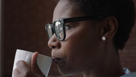 Cerrar-Retrato-Mujer-Afroamericana-Tomando-Café-En-Casa-Empresario-Negro-Disfrutando-De-Una-Mañana-Relajada-Mirando-Por-La-Ventana-Pensando-Contemplativo-Con-Gafas