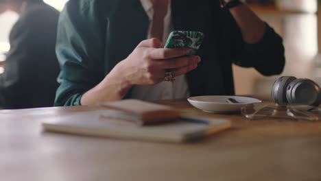 close-up-hands-young-man-using-smartphone-in-cafe-drinking-coffee-browsing-social-media-messages-enjoying-internet-communication-texting-sharing-lifestyle