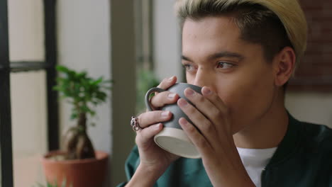 stylish-young-hispanic-man-student-drinking-coffee-at-home-looking-out-window-thinking-planning-ahead-smiling-enjoying-relaxing-lifestyle-wearing-trendy-fashion-hairstyle