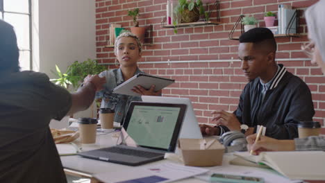 Junge-Afroamerikanische-Geschäftsfrau-Nutzt-Einen-Tablet-Computer-Und-Tauscht-Kreative-Ideen-Aus,-Präsentiert-Ein-Projekt-Und-Zeigt-Kollegen-Im-Büro,-Die-Ein-Vielfältiges-Team-Treffen,-Das-Zusammenarbeitet-Und-Eine-Brainstorming-Planungsstrategie-Durchführt