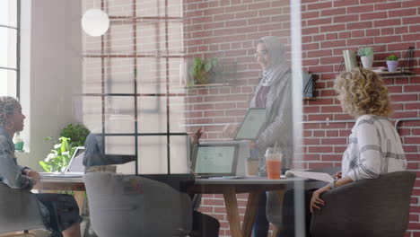 Junge-Muslimische-Geschäftsfrau-Nutzt-Einen-Digitalen-Tablet-Computer-Und-Präsentiert-Finanzdiagrammdaten,-Die-Kollegen-Im-Büro-Zeigen.-Präsentation-Eines-Vielfältigen-Teams-Bei-Der-Zusammenarbeit-Bei-Der-Brainstorming-Strategie