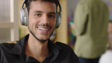 portrait-attractive-young-hispanic-man-using-smartphone-texting-social-media-messages-happy-student-smiling-enjoying-successful-startup-business-listening-to-music-in-modern-office