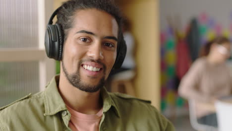 portrait-young-mixed-race-man-using-smartphone-texting-social-media-messages-happy-student-smiling-enjoying-successful-startup-business-listening-to-music-in-modern-office