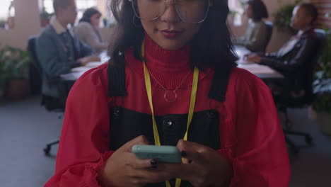 Nahaufnahme-Einer-Glücklichen-Asiatischen-Geschäftsfrau,-Die-Ihr-Smartphone-Nutzt,-Um-Social-Media-Nachrichten-Zu-Durchsuchen-Und-Auf-Dem-Mobiltelefon-SMS-Zu-Schreiben.-Sie-Genießt-Den-Vielfältigen-Büroarbeitsplatz.-Eine-Managerin-Geht-Selbstbewusst-Und-Trägt-Eine-Brille