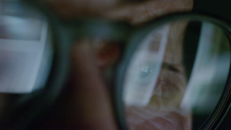 Nahaufnahme-Eines-Makro-Augenbildschirms,-Der-über-Eine-Brille-Reflektiert.-Alte-Frau,-Die-Nachts-Online-Surft