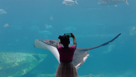 little-girl-taking-photo-of-fish-in-aquarium-using-smartphone-photographing-marine-animals-swimming-in-tank-learning-about-sea-life-in-aquatic-habitat-having-fun-in-oceanarium