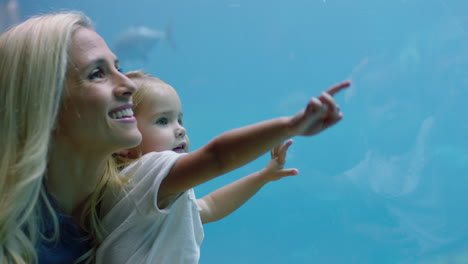 Glückliches-Mädchen-Mit-Mutter-Im-Aquarium-Und-Blick-Auf-Den-Stachelrochen,-Der-Mit-Fischen-Im-Aquarium-Schwimmt.-Kind-Beobachtet-Neugierig-Meerestiere-Und-Hat-Spaß-Daran,-Mit-Mutter-Im-Ozeanarium-Etwas-über-Das-Leben-Im-Meer-Zu-Lernen