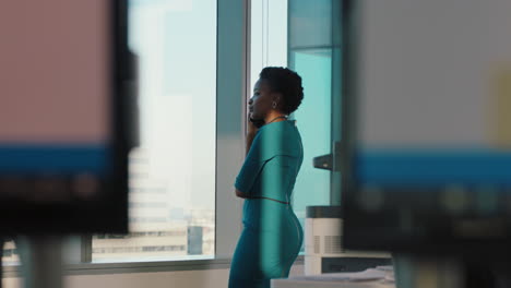 african-american-business-woman-using-smartphone-chatting-to-client-negotiating-deal-financial-advisor-sharing-expert-advice-having-phone-call-working-late-in-office-looking-out-window