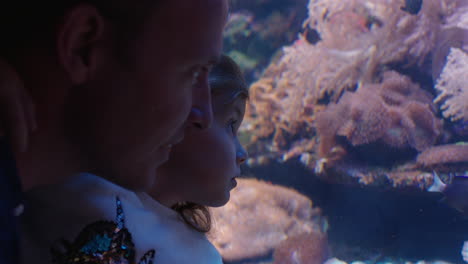 Vater-Mit-Kleinem-Mädchen-Im-Aquarium-Und-Blick-Auf-Fische,-Die-Im-Corel-Riff-Schwimmen.-Neugieriges-Kind,-Das-Meerestiere-Beobachtet-Und-Es-Genießt,-Mit-Papa-Im-Ozeanarium-Etwas-über-Das-Leben-Im-Meer-Zu-Lernen