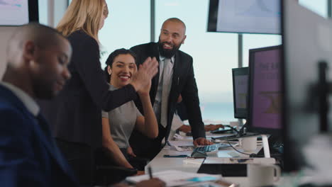 sales-team-celebrating-success-with-high-five-looking-at-financial-graph-data-on-computer-screen-happy-business-people-enjoying-corporate-victory-achievement-in-office